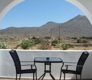 a table and two chairs on a balcony with a view at Anastasia Studios in Avlemonas