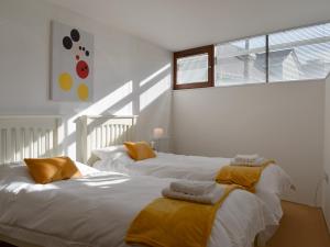 Dos camas en una habitación con paredes blancas. en 27 Nautilus, en Westward Ho 6 fotos más