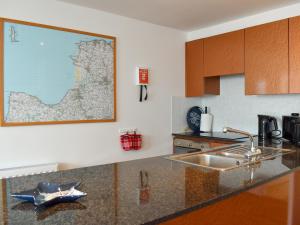 una cocina con fregadero y un mapa en la pared en 27 Nautilus, en Westward Ho