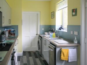 eine Küche mit Spüle und Waschmaschine in der Unterkunft Riversdale Cottage in Saint Fillans