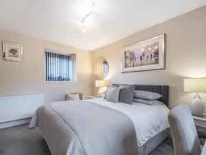 une chambre avec un grand lit blanc et une chaise dans l'établissement Shore View Cottage, à North Kessock 13 autres photos