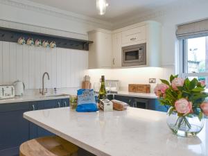 a kitchen with a counter with a vase of flowers at Brookleigh Farm Cottage in Burley in Wharfedale +21 photos
