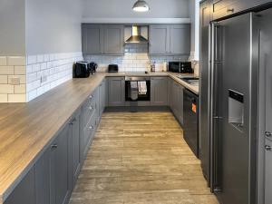 a kitchen with gray cabinets and a wooden floor at The Old School House in Eggleston