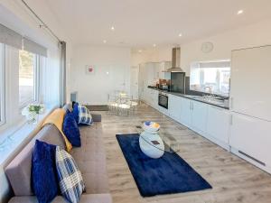 a living room with a couch and a kitchen at Strathclyde Cottage North in Skelmorlie