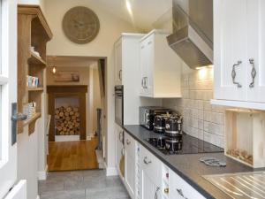 a kitchen with white cabinets and a counter top at Lantern Cottage in Lyndhurst