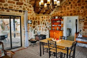 a dining room with a table and a stone wall at Riverman Cabin Country Lodge - Tonteldoos in Tonteldoos