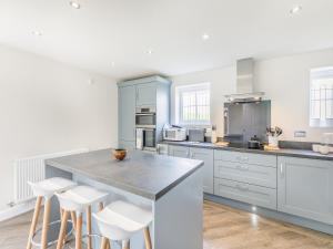 a kitchen with blue cabinets and white counter tops at Silkstone Crescent in Buxton