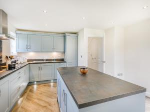 a kitchen with white cabinets and a counter top at Silkstone Crescent in Buxton