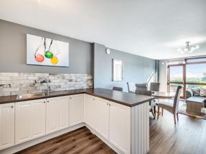 a kitchen with white cabinets and a dining room with a table at Cottage 5 - Uk38221 in Ashby cum Fenby +20 photos
