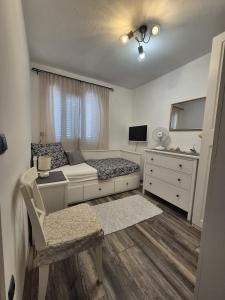 a small bedroom with a bed and a dresser at Apartman Prošperino in Vis