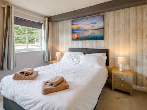 a bedroom with a large bed with two towels on it at Cottage 2 - Uk38222 in Ashby cum Fenby