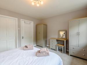 a bedroom with a white bed with two towels on it at Cottage 2 - Uk38222 in Ashby cum Fenby