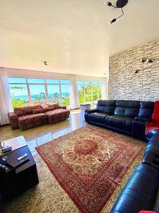 a living room with a blue leather couch and a rug at Sonho do Moreno in Vila Velha +81 photos