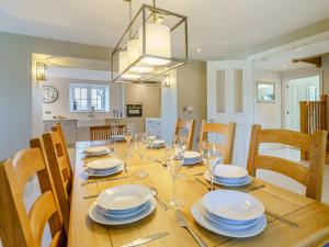 a dining room table with plates and wine glasses at Bwlchsais in Hermon +32 photos