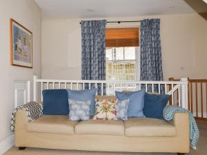 eine Couch mit Kissen in einem Raum mit einem Fenster in der Unterkunft Courtenay Street 5 in Salcombe
