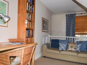 ein Wohnzimmer mit einer Couch und einem Bücherregal in der Unterkunft Courtenay Street 5 in Salcombe