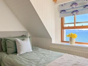 a bedroom with a bed and a window with the ocean at The Fisherman's Cottage in Applecross