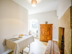 a dining room with a table and a wooden cabinet at Glebelands Lodge in Alnwick