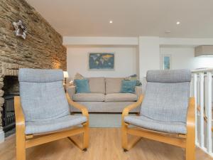 2 Stühle und ein Sofa im Wohnzimmer in der Unterkunft Dayan Cottage in Fowey
