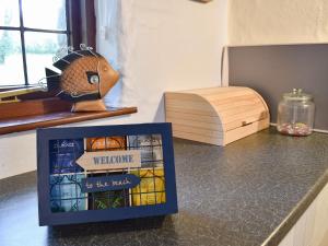 ein Buch auf einer Theke mit einer Schachtel darauf in der Unterkunft Ivory Cottage in Woolacombe