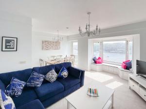 a living room with a blue couch and a table at Anchor Loft in Fowey +32 photos