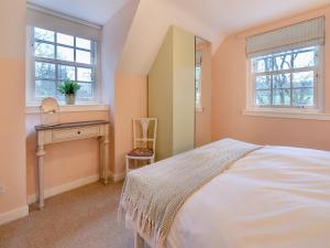 a bedroom with a bed and a mirror at River Cottage in Enochdhu
