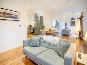 a living room with a couch and a kitchen at Bay Cottage in Tondu