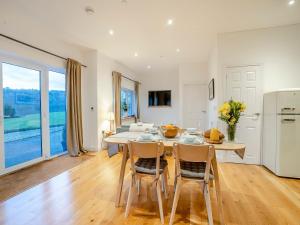a kitchen and dining room with a table and chairs at Bay Cottage in Tondu
