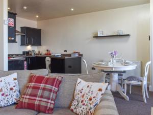 Una sala de estar con un sofá y una mesa y una cocina. en Beauty Abounds, en Morecambe