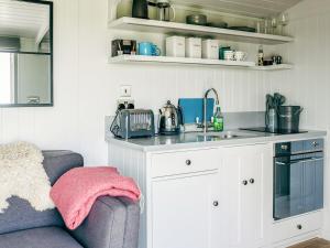 a kitchen with a counter and a sink and a couch at Phoebe's Folly-Uk36581 in Milton Abbot