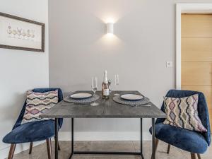 Una mesa de comedor con dos sillas azules y una mesa plegable. en River Coombe, en Dartmouth