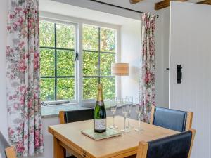 a dining room table with a bottle of wine and glasses at Eton Cottage in Farnham
