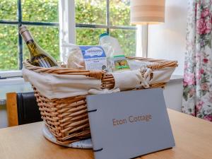 a basket with a bottle of wine and a box at Eton Cottage in Farnham