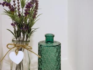 a vase with purple flowers and a green bottle with a heart at Pemberly in Winchester +10 photos