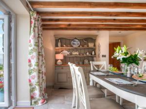Una cocina y un comedor con mesa y sillas. en Ty Gan Y Mor, en Nefyn