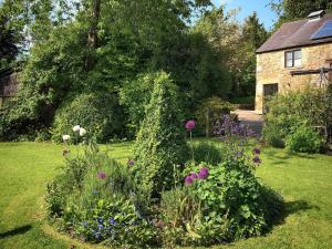 a garden with flowers in front of a house at Calico Cottage in Hope