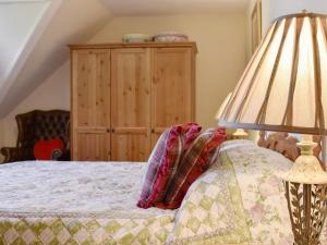 a bedroom with a bed with a lamp and a dresser at The Loft - Uk34070 in Lynton