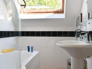 a bathroom with a sink and a bath tub and a window at The Loft - Uk34070 in Lynton