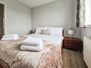 a bedroom with a bed with towels on it at Havrock in Kirkwall +3 photos