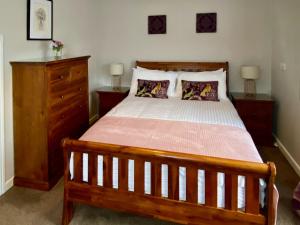 a bedroom with a wooden bed and a wooden dresser at Townhouse - Uk48078 in Kirkwall