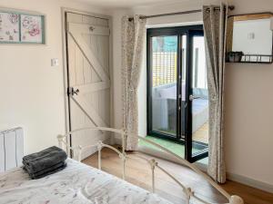 a bedroom with a bed and a sliding glass door at Hop Cottage in Sellindge