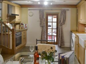 a kitchen with a table with wine glasses on it at St Francis Cottage in Seathwaite