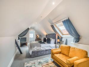 a bedroom with a bed and a couch at Sea Breeze House in Skegness