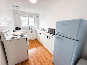 a white kitchen with a refrigerator and a stove at Halloran 2 in Wagga Wagga