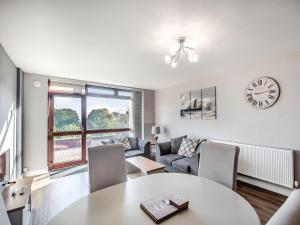 a living room with a table and a clock on the wall at Cottage 5 - Uk38221 in Ashby cum Fenby