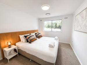 a bedroom with a large white bed with a window at Halloran 2 in Wagga Wagga