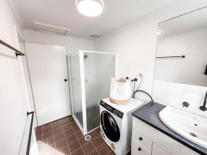 a bathroom with a washing machine and a sink at Halloran 2 in Wagga Wagga