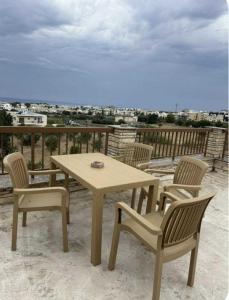 a wooden table and chairs on a balcony with a view at Stellas superior home in Paphos City