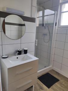 Un baño con lavabo y ducha con espejo. en La maison "Ty Lichoux", en Plouha