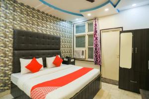 a bedroom with a large bed with red pillows at RROOMS Eco Hotel Nimisha in Sītāpur